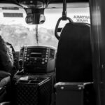 Een buschauffeur rijdt door het Westland, met passagiers aan boord en een prachtig landschap op de achtergrond.